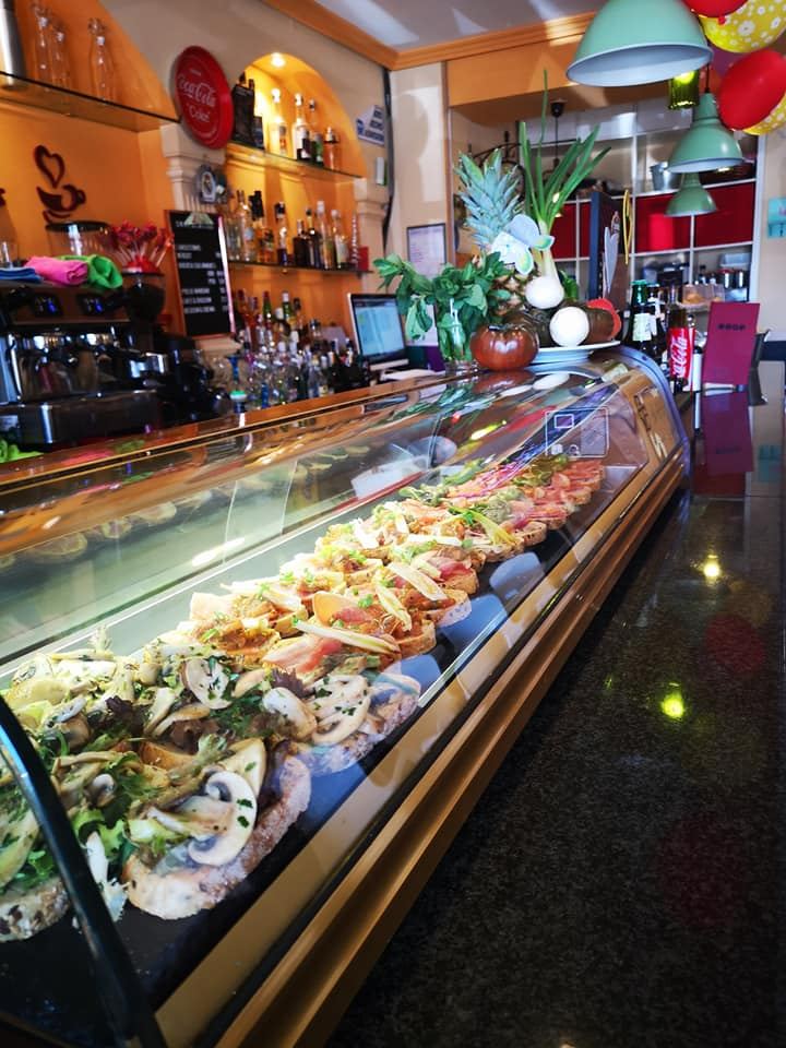 Surtido de tostas variadas con ingredientes frescos sobre la barra.
